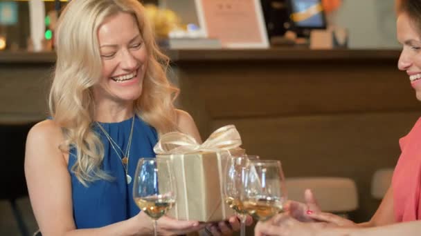 Frauen beschenken Freundin in Weinbar — Stockvideo