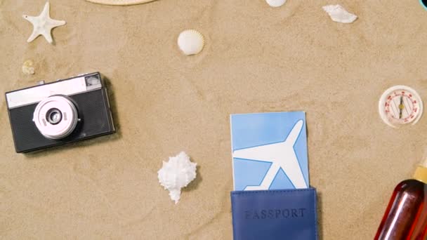 Billetes de viaje, cámara y sombrero en arena de playa — Vídeos de Stock