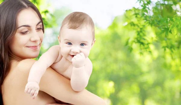 Moeder met baby over groene natuurlijke achtergrond — Stockfoto