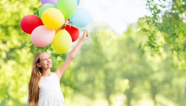 Glad tjej med ballonger över naturliga bakgrund — Stockfoto