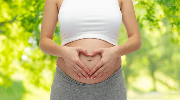 Kobieta w ciąży co gest serca z bliska — Zdjęcie stockowe