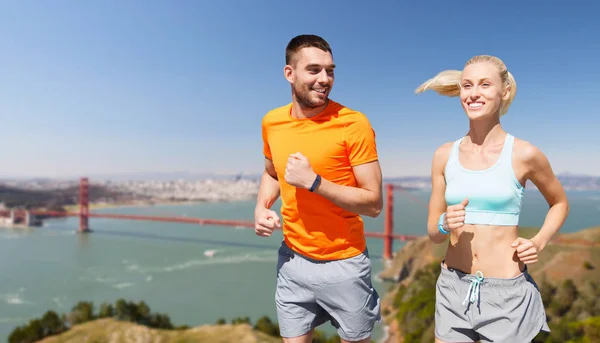 Feliz pareja corriendo sobre Golden Gate puente — Foto de Stock