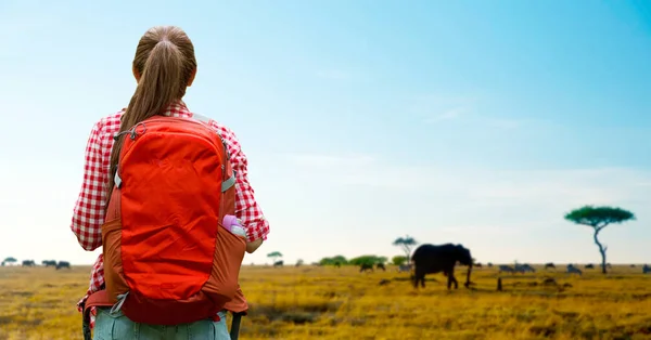 Frau mit Rucksack über afrikanische Savanne — Stockfoto