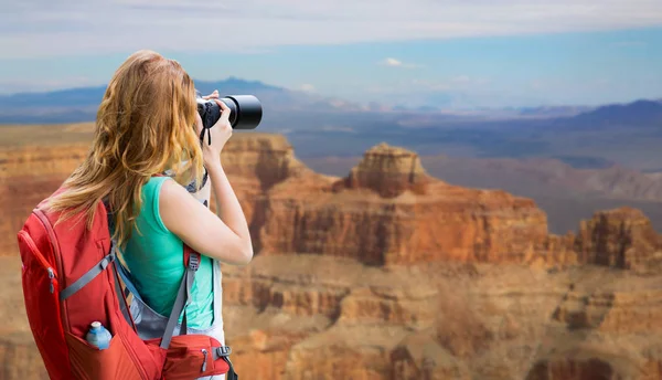 Vrouw met rugzak en camera op de grand canyon — Stockfoto