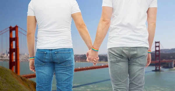 Pareja masculina con brazaletes de arco iris orgullo gay —  Fotos de Stock