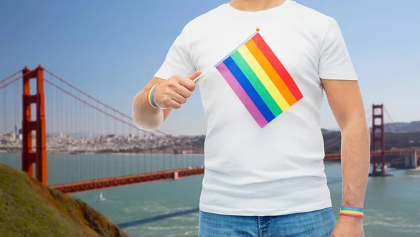 Hombre con bandera de arco iris y pulseras de orgullo gay —  Fotos de Stock