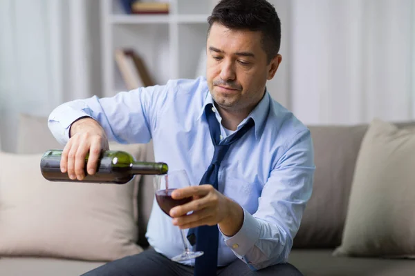 Αλκοολούχα έκχυση κόκκινο κρασί σε ποτήρι στο σπίτι — Φωτογραφία Αρχείου