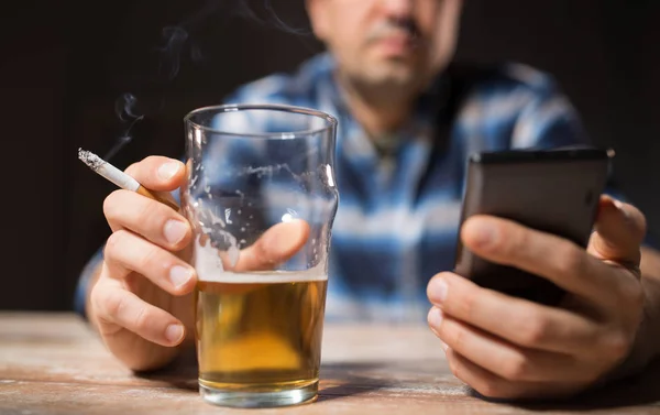 Homem com telefone celular beber álcool e fumar — Fotografia de Stock