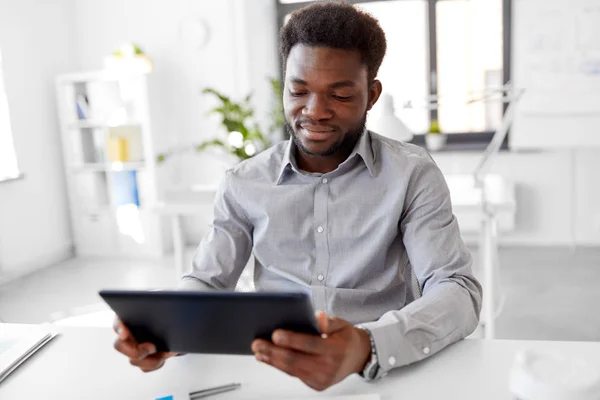 Homem de negócios africano com tablet pc no escritório — Fotografia de Stock