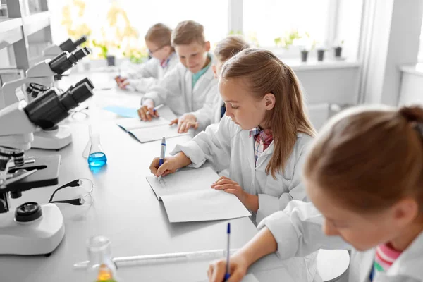 Bambini che studiano chimica al laboratorio scolastico — Foto Stock