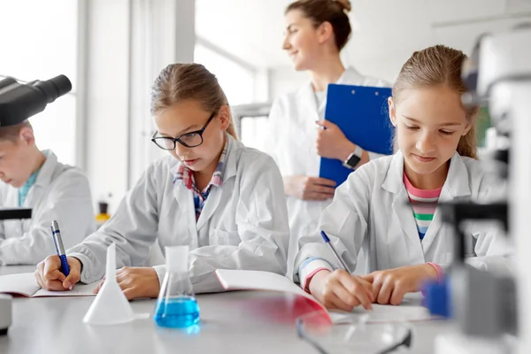 Professor e alunos que estudam química na escola — Fotografia de Stock