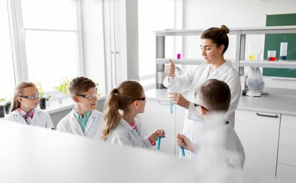 Professor e alunos que estudam química na escola — Fotografia de Stock