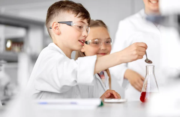 Niños con probeta que estudian química en la escuela — Foto de Stock
