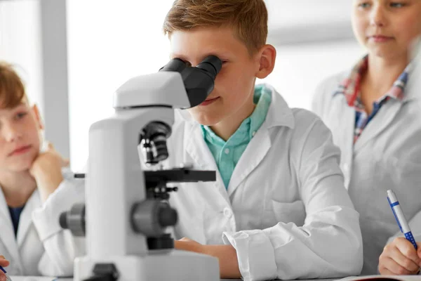 kids or students with microscope biology at school