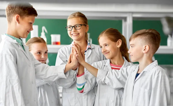 Crianças felizes fazendo alta cinco no laboratório da escola — Fotografia de Stock