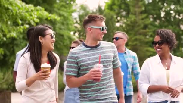 Друзья пьют кофе и трясутся, гуляя в парке — стоковое видео