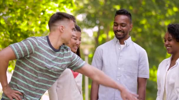 Glada vänner stapling händer i sommaren park — Stockvideo