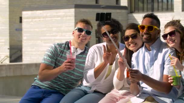 Amigos tomando fotos por selfie stick en la ciudad — Vídeo de stock