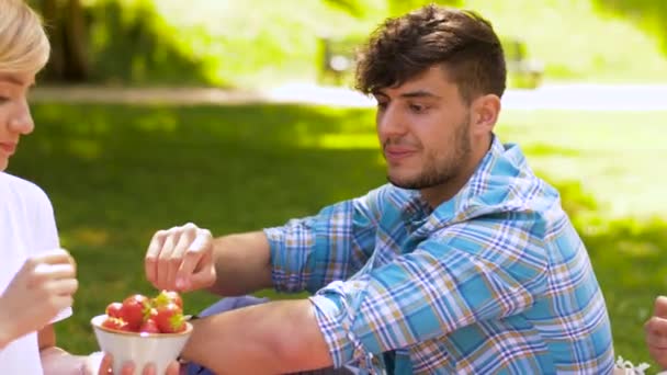 愉快的朋友吃草莓在夏天野餐 — 图库视频影像