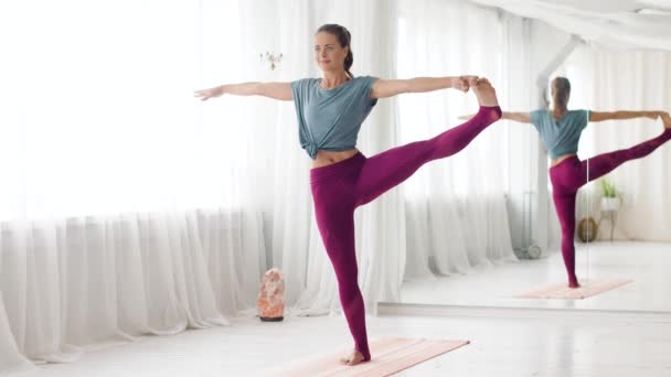 妇女做瑜伽手到大脚趾姿势在演播室 — 图库视频影像
