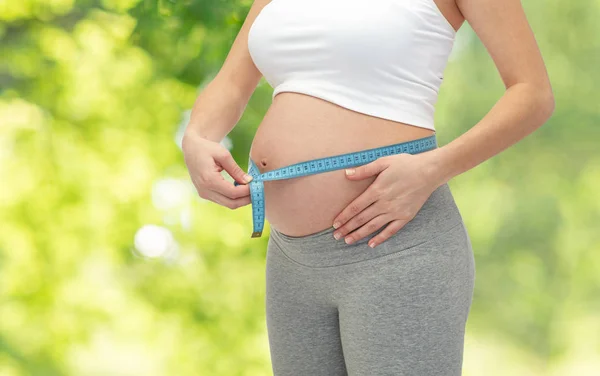 Zwangere vrouw buik meten door meetlint — Stockfoto