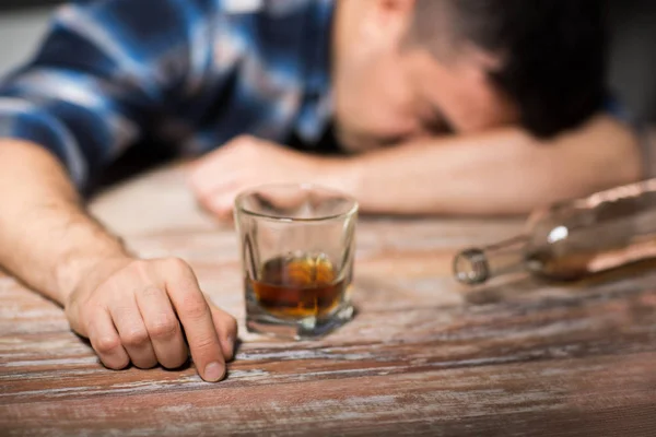 Részeg ember a pohár alkohol asztalra éjjel — Stock Fotó