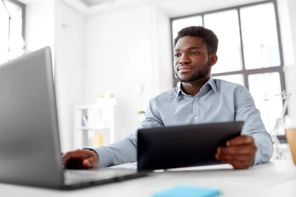 Homem de negócios com laptop e tablet pc no escritório — Fotografia de Stock