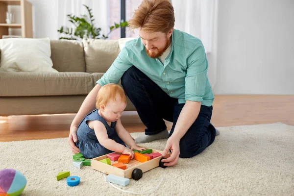 Отец и ребенок играют с игрушками блоки дома — стоковое фото