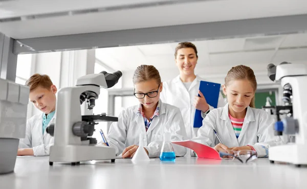 Insegnante e studenti che studiano chimica a scuola — Foto Stock