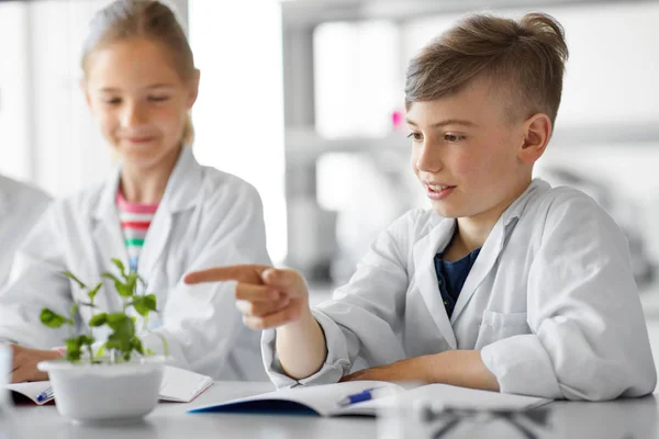 Діти або студенти з рослинами на уроці біології — стокове фото