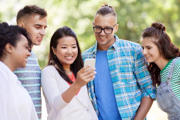 Grupo de amigos felices con teléfono inteligente al aire libre — Foto de Stock