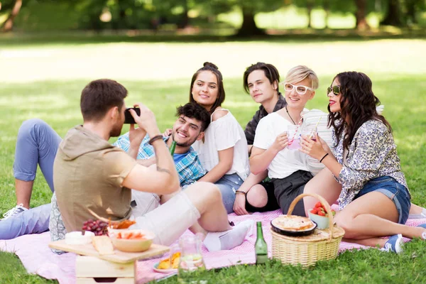 Friends photographing at picnic in summer park — Stock Photo, Image