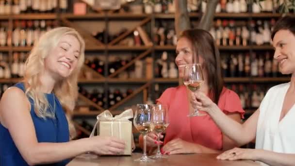 Женщины дарят подарок другу в винном баре — стоковое видео
