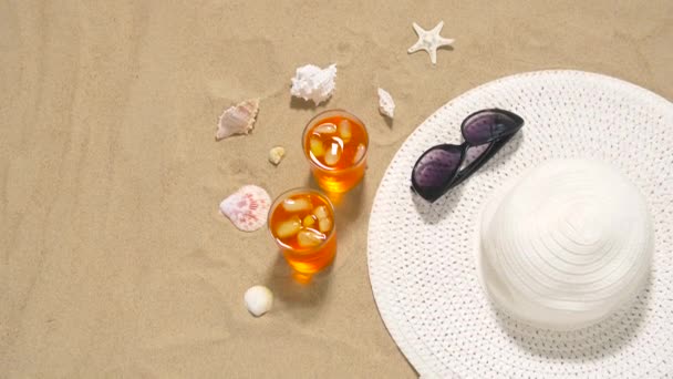 Coquetéis, chapéu de sol e óculos de sol na areia da praia — Vídeo de Stock