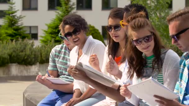 Группа счастливых студентов с блокнотами в кампусе — стоковое видео