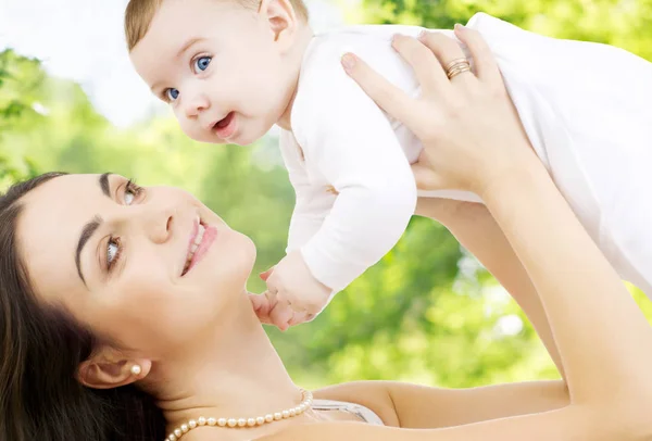 Mother with baby over green natural background — Stock Photo, Image