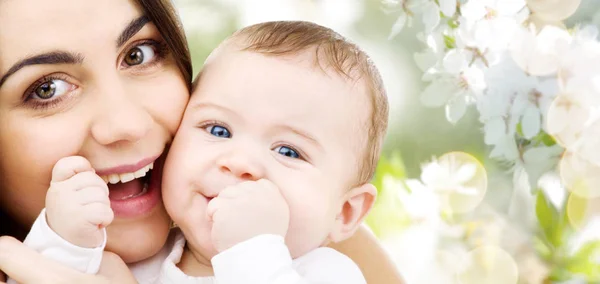Matka s dítětem nad pozadím třešňový květ — Stock fotografie