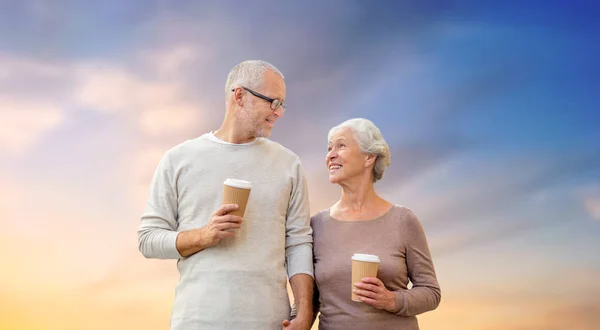 Happy senior couple with coffee over evening sky — Stock Photo, Image
