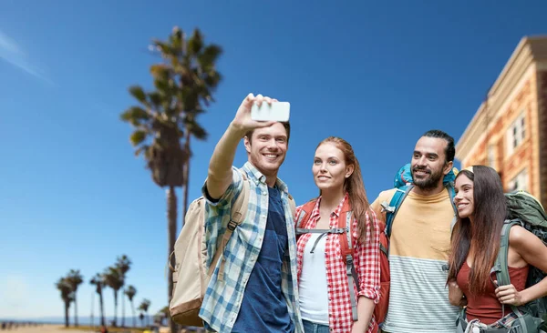 Vrienden met rugzak nemen selfie door smartphone — Stockfoto