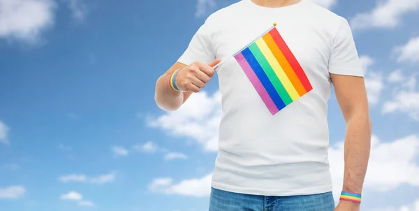 Man met regenboog vlag en gay trots polsbandjes — Stockfoto