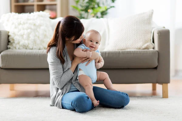 Feliz joven madre con pequeño bebé en casa —  Fotos de Stock