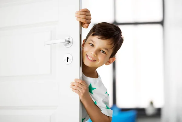 Glücklicher kleiner Junge hinter Tür zu Hause — Stockfoto