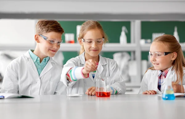 Дети с пробиркой изучают химию в школе — стоковое фото