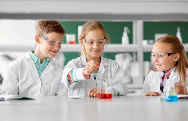 Niños con probeta que estudian química en la escuela — Foto de Stock