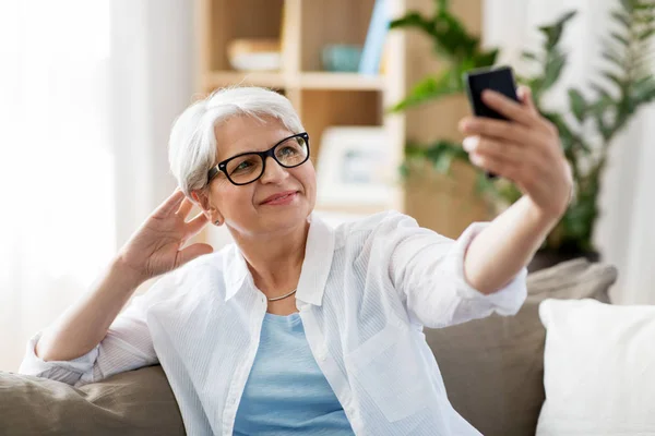 Donna anziana che prende selfie da smartphone a casa — Foto Stock