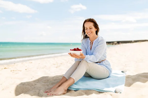 Glückliche Frau mit Erdbeeren am Sommerstrand — Stockfoto