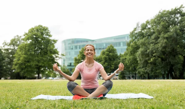 Lycklig kvinna mediterar i sommaren park — Stockfoto