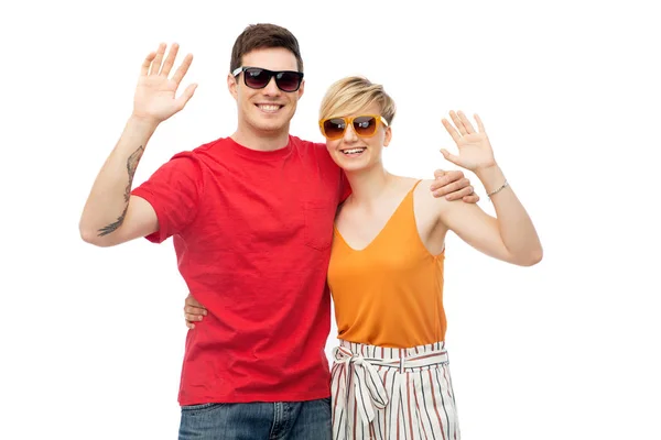 Pareja en gafas de sol abrazando y saludando las manos — Foto de Stock