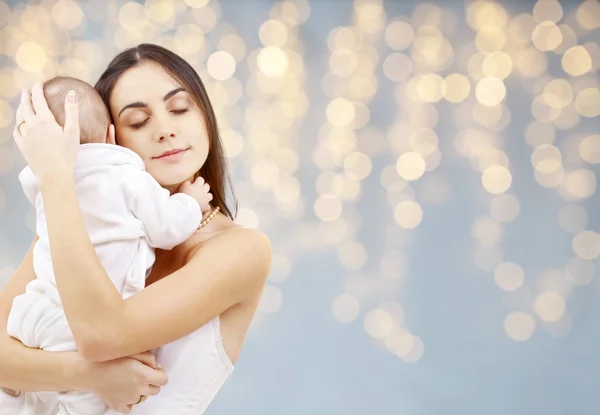 Matka s dítětem přes slavnostní osvětlení pozadí — Stock fotografie