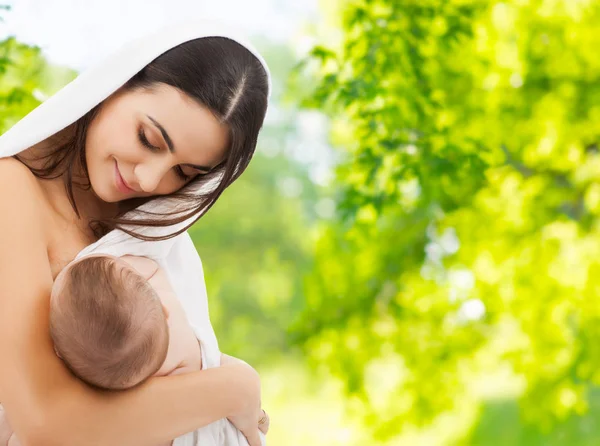 Mother breast feeding baby over natural background — Stock Photo, Image